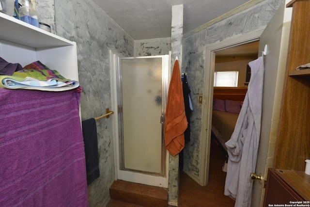 bathroom with hardwood / wood-style floors and a shower with shower door