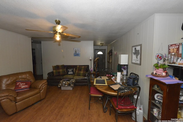 dining room with hardwood / wood-style flooring, ceiling fan, and a textured ceiling