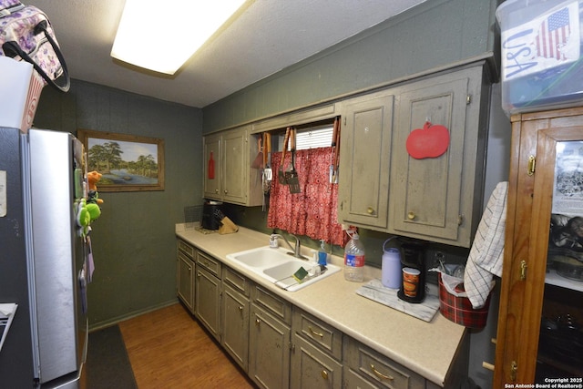 kitchen with stainless steel fridge, light hardwood / wood-style flooring, and sink