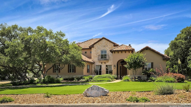 mediterranean / spanish-style home featuring a front yard