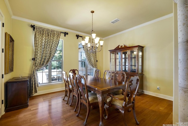 dining room featuring crown molding, hardwood / wood-style floors, and a chandelier