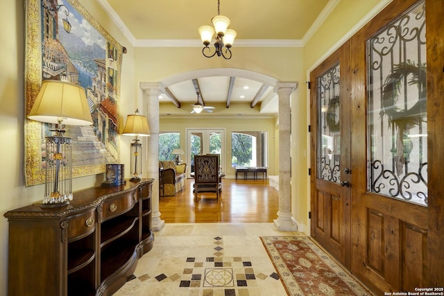 foyer with beam ceiling, ornate columns, french doors, and ornamental molding