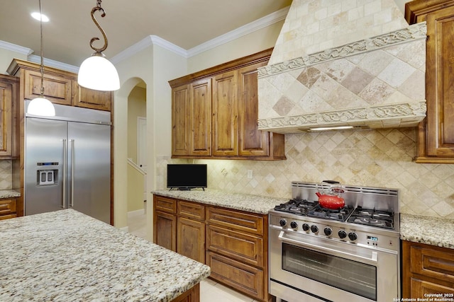 kitchen featuring high end appliances, backsplash, ornamental molding, light stone counters, and custom range hood