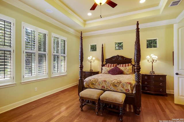 bedroom featuring a raised ceiling, ceiling fan, and ornamental molding