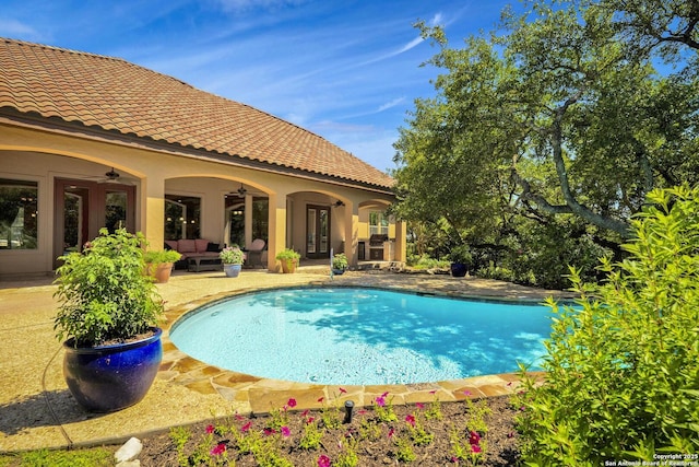 view of swimming pool with ceiling fan, a patio area, and an outdoor living space