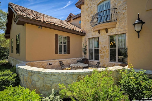 back of property with a balcony and a patio