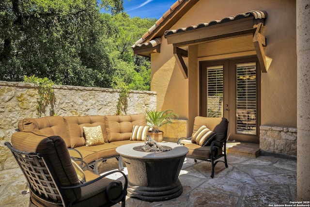 view of patio / terrace featuring french doors and an outdoor living space with a fire pit