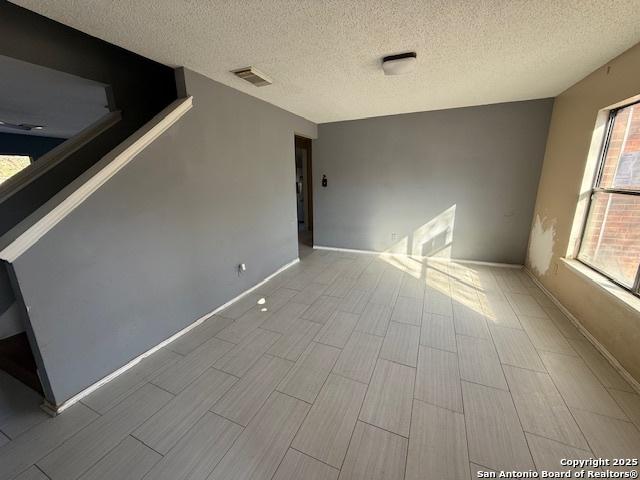 unfurnished room featuring a textured ceiling