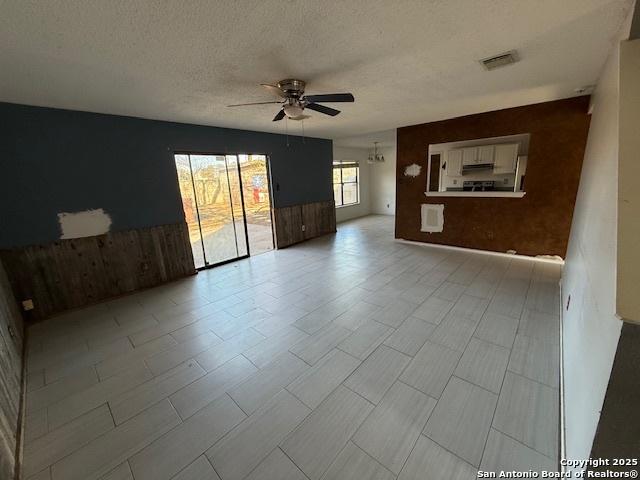 empty room featuring ceiling fan and a textured ceiling