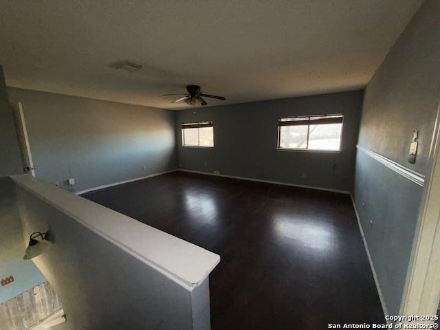 spare room with ceiling fan and dark wood-type flooring