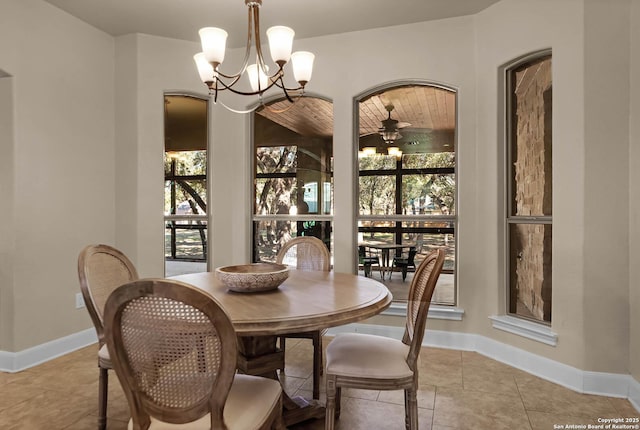 tiled dining room featuring a healthy amount of sunlight and ceiling fan with notable chandelier