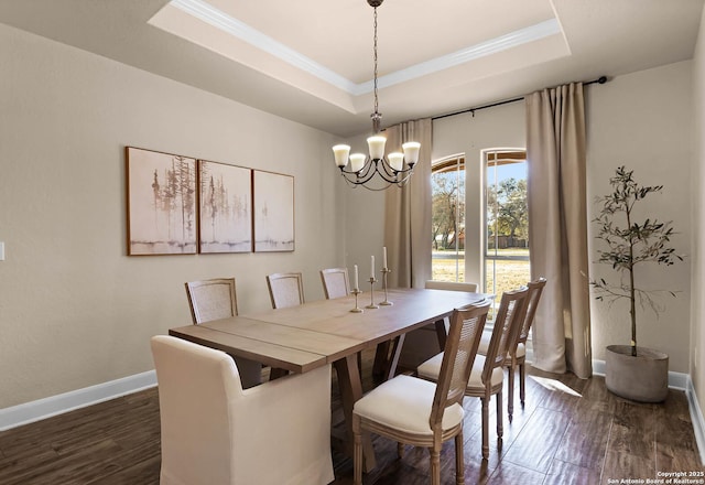 dining space featuring a raised ceiling, dark hardwood / wood-style flooring, and a chandelier