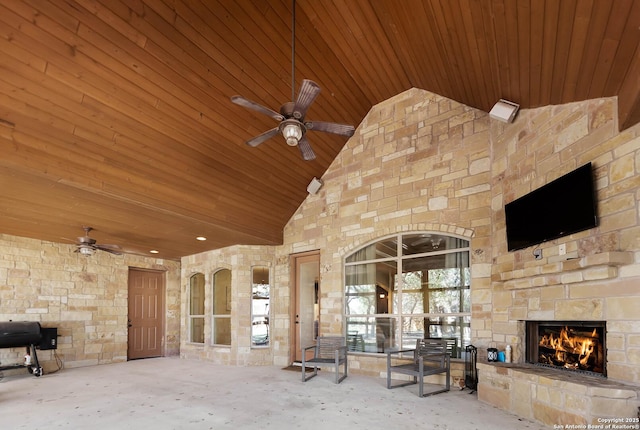 view of patio featuring an outdoor stone fireplace, grilling area, and ceiling fan