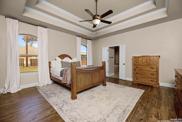 bedroom with a raised ceiling, ceiling fan, dark hardwood / wood-style floors, and ornamental molding