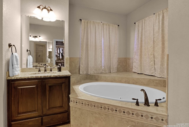 bathroom featuring vanity and tiled tub