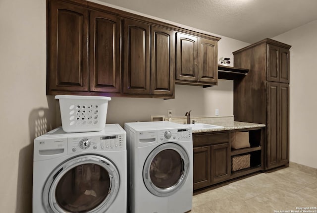 laundry area featuring cabinets, independent washer and dryer, a textured ceiling, and sink