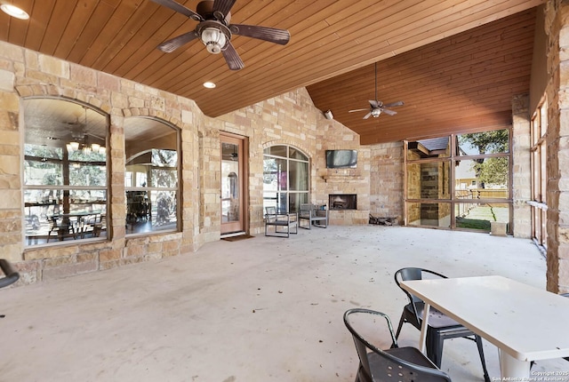 view of patio with an outdoor stone fireplace and ceiling fan