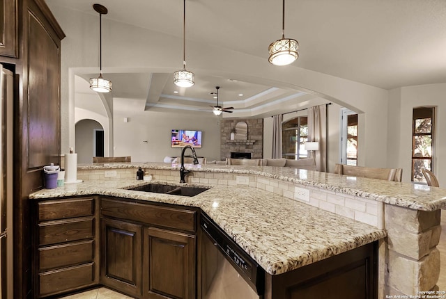 kitchen with dark brown cabinets, a raised ceiling, ceiling fan, sink, and dishwasher