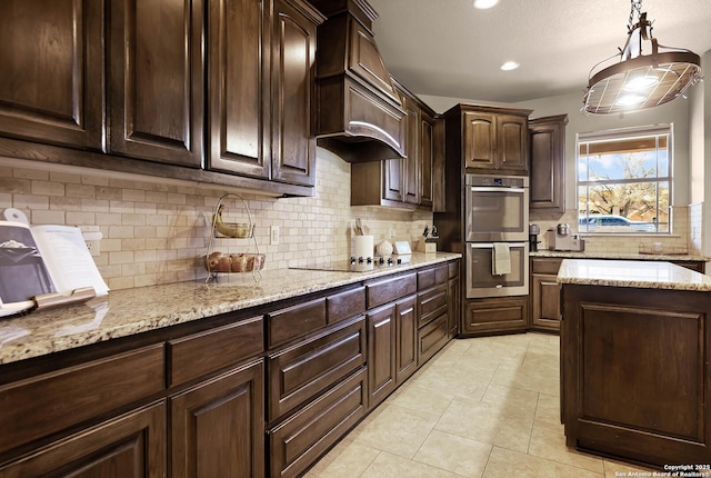 kitchen featuring dark brown cabinetry, double oven, decorative light fixtures, decorative backsplash, and black electric stovetop