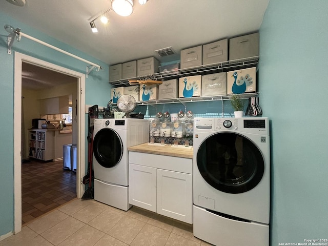 laundry room featuring cabinets, separate washer and dryer, and light tile patterned floors