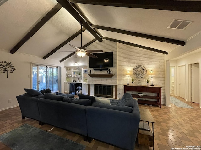 living room featuring vaulted ceiling, a brick fireplace, ceiling fan, and a textured ceiling