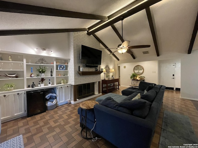 living room featuring lofted ceiling with beams, a brick fireplace, and ceiling fan