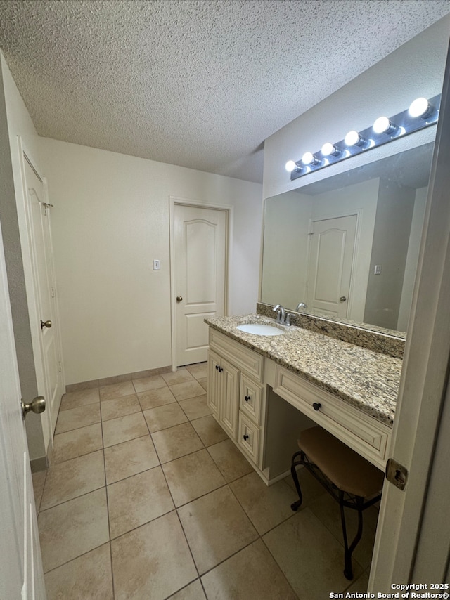 bathroom featuring tile patterned floors, vanity, and a textured ceiling