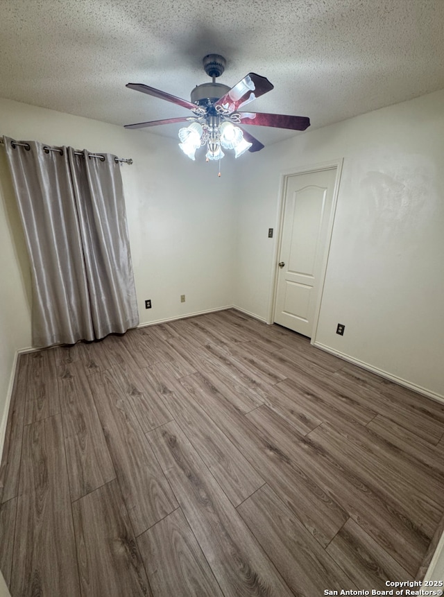 empty room featuring a textured ceiling, hardwood / wood-style flooring, and ceiling fan