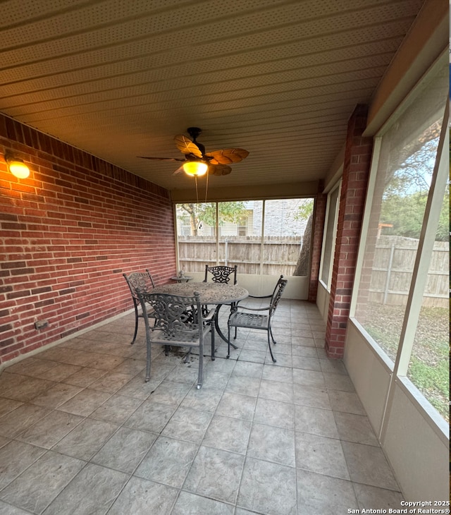 unfurnished sunroom featuring ceiling fan