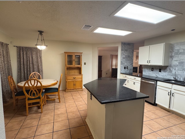 kitchen with a center island, dishwasher, sink, backsplash, and white cabinets