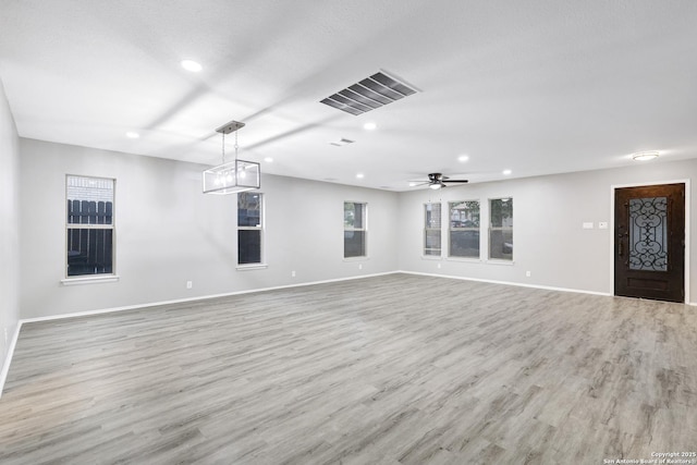 unfurnished living room featuring a textured ceiling, light hardwood / wood-style floors, and ceiling fan