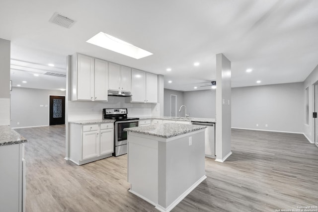 kitchen with white cabinets, ceiling fan, light stone counters, kitchen peninsula, and stainless steel appliances