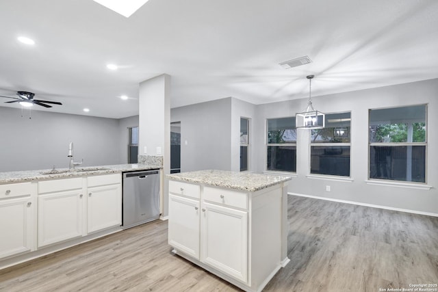 kitchen featuring stainless steel dishwasher, sink, pendant lighting, white cabinets, and a kitchen island