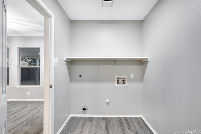 clothes washing area with hookup for an electric dryer, light hardwood / wood-style floors, gas dryer hookup, and hookup for a washing machine