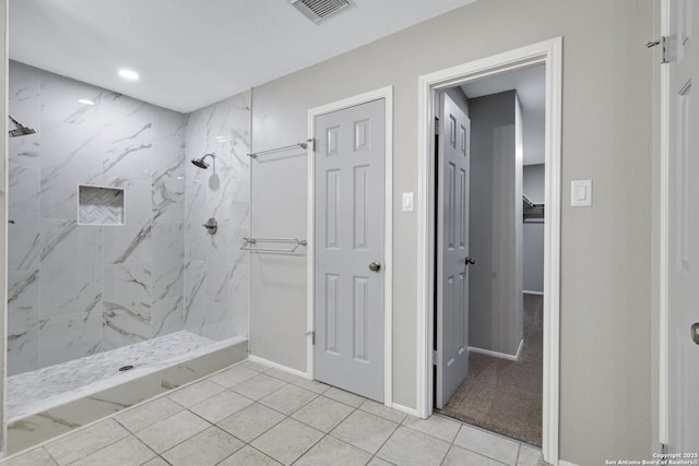 bathroom featuring a tile shower and tile patterned floors