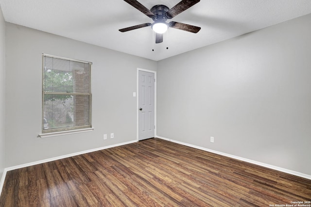 empty room featuring dark hardwood / wood-style flooring and ceiling fan