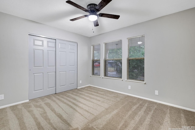 unfurnished bedroom featuring ceiling fan, carpet floors, and a closet