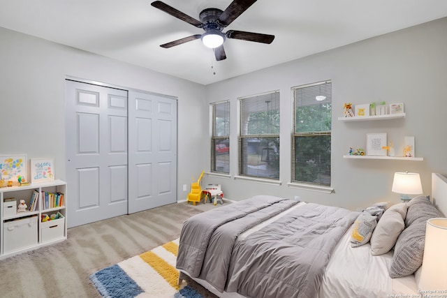 carpeted bedroom featuring ceiling fan and a closet