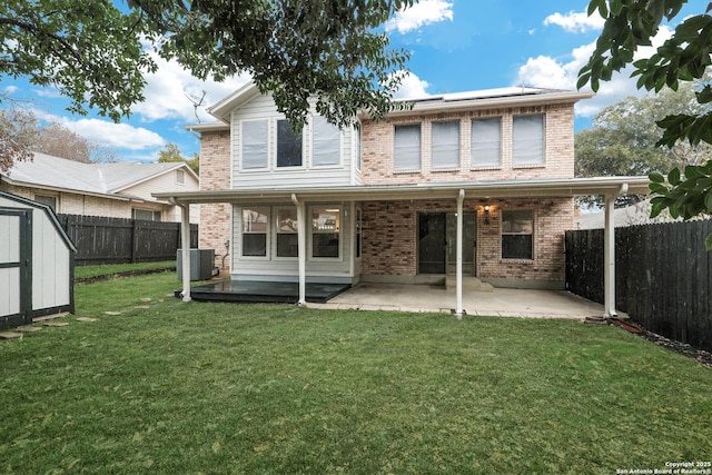 rear view of house with a patio area, a yard, central AC unit, and a shed