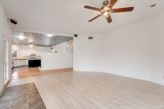 unfurnished living room with ceiling fan and light wood-type flooring