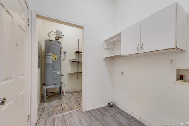 laundry area featuring electric dryer hookup, cabinets, electric water heater, hookup for a washing machine, and light wood-type flooring