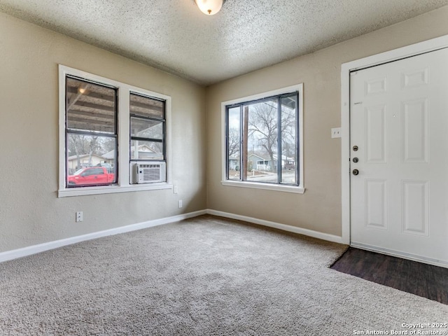 carpeted foyer featuring cooling unit and a textured ceiling