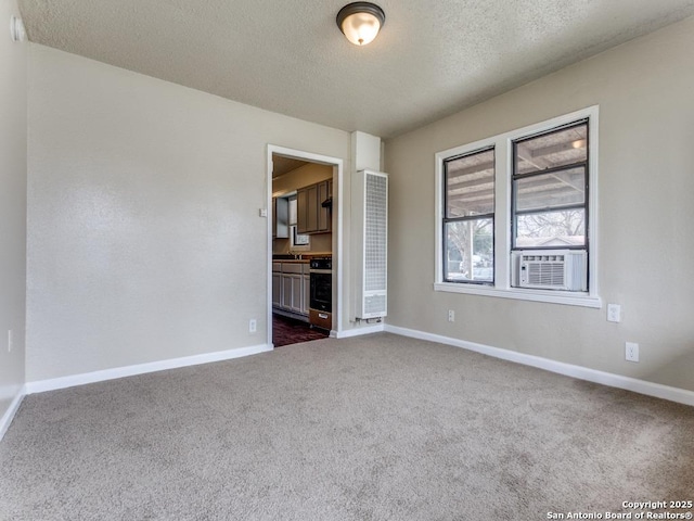 unfurnished room with a textured ceiling and dark colored carpet