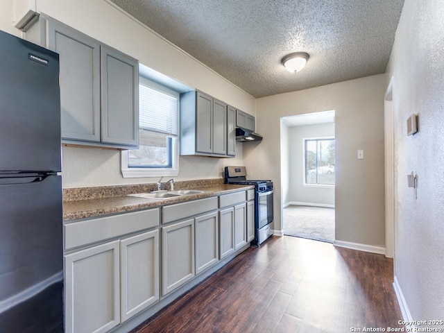 kitchen featuring gray cabinetry, sink, dark hardwood / wood-style floors, a textured ceiling, and appliances with stainless steel finishes