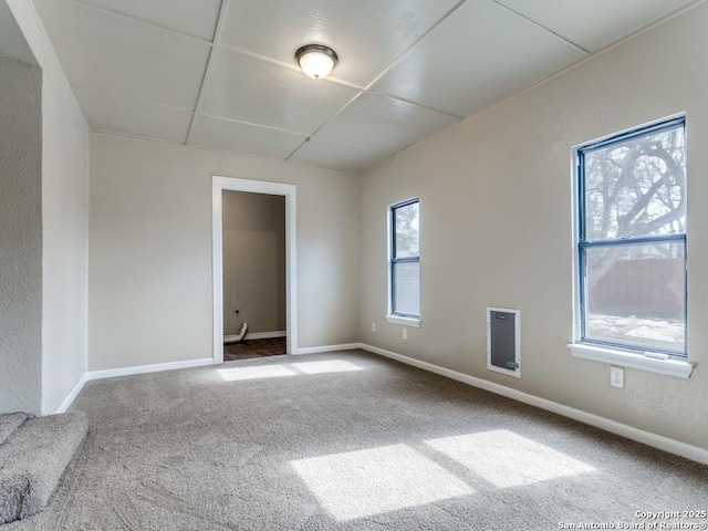 unfurnished room featuring carpet flooring and a drop ceiling