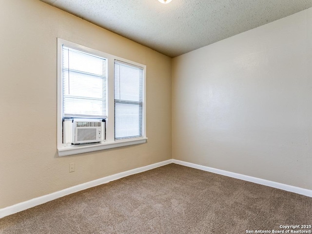 empty room featuring cooling unit, carpet floors, and a textured ceiling