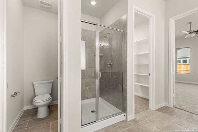 bathroom with ceiling fan, a shower with shower door, tile patterned floors, and toilet