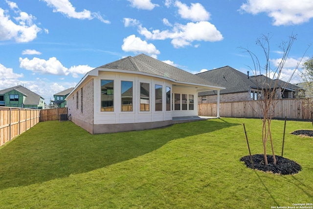 rear view of house featuring central AC and a lawn