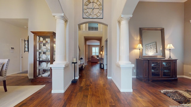 entryway with a towering ceiling and dark hardwood / wood-style flooring