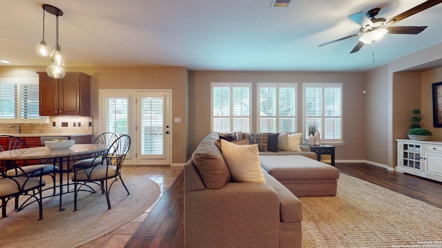 living room with ceiling fan, dark hardwood / wood-style floors, and sink